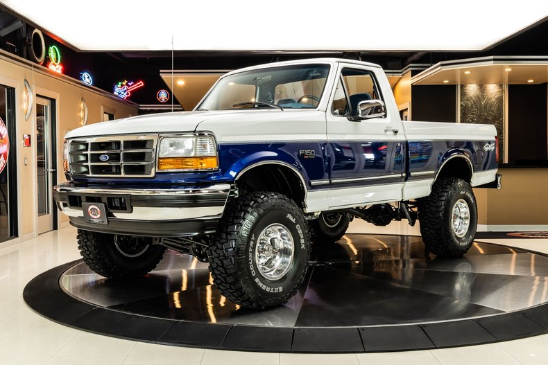 Blue and white OBS Ford F-150 truck in a showroom